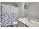 Bright bathroom featuring a floral shower curtain, toilet and vanity with marble countertop at 122 Grove View Rd, Woodstock, GA 30189