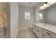 Bright bathroom featuring neutral tiling, white vanity, and a framed mirror providing a clean and functional space at 122 Grove View Rd, Woodstock, GA 30189