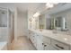 Bright bathroom with double sink vanity, a large mirror, and a glass enclosed shower and tub at 122 Grove View Rd, Woodstock, GA 30189