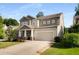 A gray two-story home with a two-car garage, a manicured front yard, and a welcoming entrance at 122 Grove View Rd, Woodstock, GA 30189