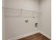 Minimalist laundry room featuring white walls, wood floor, and shelving rack at 122 Grove View Rd, Woodstock, GA 30189