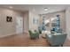 Sitting area featuring multiple blue armchairs, a center ottoman, and decorative floral curtains at 122 Grove View Rd, Woodstock, GA 30189