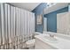 Charming bathroom featuring blue walls, white vanity, and a decorative shower curtain at 3310 Southlake Ln, Cumming, GA 30041