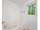 Bright bathroom showcasing a soaking tub beneath a window providing ample natural light at 3310 Southlake Ln, Cumming, GA 30041