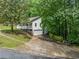 Charming white home with a welcoming front porch, attached garage, and lush green surroundings at 3310 Southlake Ln, Cumming, GA 30041