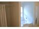 This bathroom has a tub-shower combination with a curtain and a garden tub under the window at 4450 Ivy Fork Dr, Loganville, GA 30052