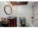 This updated bathroom features modern lighting, shiplap walls, and a shower-tub combination at 549 Atwood Sw St, Atlanta, GA 30310