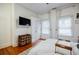 Cozy bedroom featuring wood floors, a TV, an area rug, and bright natural light at 549 Atwood Sw St, Atlanta, GA 30310