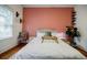 Bedroom with salmon accent wall, modern decor, wooden floors, and bright natural light at 549 Atwood Sw St, Atlanta, GA 30310