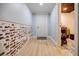 Basement hallway with brick accent wall, laminate flooring, and a view to the bathroom at 549 Atwood Sw St, Atlanta, GA 30310