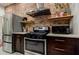 Kitchen with stainless steel appliances, exposed brick wall, and stylish decor at 549 Atwood Sw St, Atlanta, GA 30310