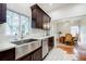 Bright kitchen featuring dark wood cabinets, stainless steel farmhouse sink, and white subway tile backsplash at 549 Atwood Sw St, Atlanta, GA 30310