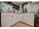 Bright kitchenette featuring white cabinets, granite counters, gold fixtures, and wooden shelves at 549 Atwood Sw St, Atlanta, GA 30310