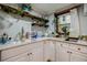 Bright kitchenette featuring white cabinets, granite counters, gold fixtures, and wooden shelves at 549 Atwood Sw St, Atlanta, GA 30310