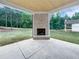 Covered outdoor patio area with a stone fireplace and backyard views at 1465 Leach Dr, Lawrenceville, GA 30045