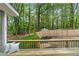 A view of the wooden deck, pillows and backyard with mature trees and a privacy fence at 2110 Argyle Se Dr, Smyrna, GA 30080