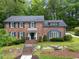 Charming two-story brick home featuring a well-manicured lawn and a serene water feature at 2719 Cravey Ne Dr, Atlanta, GA 30345