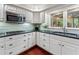 Modern kitchen with white cabinets, stainless steel appliances, granite countertops, and hardwood floors at 2719 Cravey Ne Dr, Atlanta, GA 30345