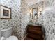 Charming powder room featuring unique wallpaper, a pedestal sink, and elegant lighting fixtures at 2719 Cravey Ne Dr, Atlanta, GA 30345