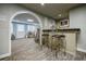Finished basement featuring a stylish bar area with seating and an arched entrance to a recreation space at 5318 Brooke Farm Dr, Dunwoody, GA 30338