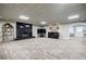 Open basement area with a black tiled fireplace, neutral walls, and direct access to a seating area at 5318 Brooke Farm Dr, Dunwoody, GA 30338