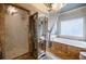 Bathroom features a bathtub with elegant fixtures and a glass door shower at 5318 Brooke Farm Dr, Dunwoody, GA 30338