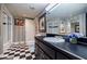 Modern bathroom featuring black and white checkered floor, vanity, and glass-enclosed shower at 5318 Brooke Farm Dr, Dunwoody, GA 30338