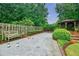 Gravel bocce ball court with bench seating, mature plantings and a gazebo in a lush backyard at 5318 Brooke Farm Dr, Dunwoody, GA 30338