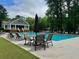 Community pool surrounded by lounge chairs and umbrellas, with a clubhouse in the background at 5318 Brooke Farm Dr, Dunwoody, GA 30338