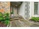 Close-up of the home's front door with stone accents and elegant landscaping at 5318 Brooke Farm Dr, Dunwoody, GA 30338