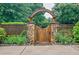Beautiful garden gate with stone pillars and wooden archway at 5318 Brooke Farm Dr, Dunwoody, GA 30338