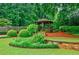 A charming gazebo nestled amongst lush greenery and landscaping in this home's beautiful backyard at 5318 Brooke Farm Dr, Dunwoody, GA 30338