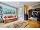 Sunroom with hardwood floors, comfortable sofa, and views of the outside garden at 5318 Brooke Farm Dr, Dunwoody, GA 30338