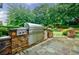 Outdoor kitchen featuring stone accents, stainless steel appliances, and a built-in grill at 5318 Brooke Farm Dr, Dunwoody, GA 30338