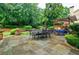 Spacious outdoor patio featuring a dining table, lush landscaping, and comfortable seating at 5318 Brooke Farm Dr, Dunwoody, GA 30338