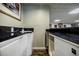 Finished basement wet bar with dark countertops, white cabinets and sink at 5318 Brooke Farm Dr, Dunwoody, GA 30338