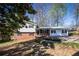 Charming two-story home with brick accents and a green metal roof, set on a landscaped lot at 6225 Pebble Dr, Douglasville, GA 30135
