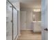Modern bathroom features a glass-enclosed shower, sleek fixtures, and a vanity with ample storage, and light wood floors at 907 Eagle Ave, Riverdale, GA 30296