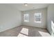 Bedroom featuring wall-to-wall carpet, two windows, and natural light at 907 Eagle Ave, Riverdale, GA 30296