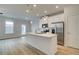 Open-concept kitchen features white cabinets, stainless steel appliances, and an island at 907 Eagle Ave, Riverdale, GA 30296