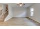 Spacious living room featuring wood-look flooring, ceiling fan, window and staircase at 907 Eagle Ave, Riverdale, GA 30296