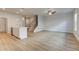 Bright living room featuring wood-look flooring, ceiling fan, and open access to the kitchen and a carpeted staircase at 907 Eagle Ave, Riverdale, GA 30296