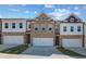 New townhomes with brick and siding exteriors, attached garages, and driveway at 907 Eagle Ave, Riverdale, GA 30296