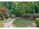 Beautifully landscaped backyard with mature trees, stone pathway, and lush greenery for a private and serene outdoor space at 1236 Whitlock Ridge Sw Dr, Marietta, GA 30064