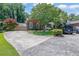 A wide driveway leads to a brick home with lush landscaping, mature trees, and parking for multiple vehicles at 1236 Whitlock Ridge Sw Dr, Marietta, GA 30064