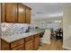 Open-concept kitchen featuring wooden cabinets, granite countertops, and view into the adjacent dining room at 1236 Whitlock Ridge Sw Dr, Marietta, GA 30064