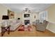 Cozy living room with a fireplace, ceiling fan, neutral walls and warm-toned hardwood floors at 1236 Whitlock Ridge Sw Dr, Marietta, GA 30064