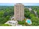 This aerial view shows a brick highrise with a pool and wooded area in a quiet community at 1501 Clairmont Rd # 1213, Decatur, GA 30033