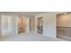Upstairs carpeted hallway featuring a wood and iron banister, a laundry closet, and neutral paint at 162 Haverling Pass, Hampton, GA 30252