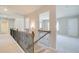 Carpeted hallway featuring a wood and iron banister, doorways to other rooms, and neutral paint at 162 Haverling Pass, Hampton, GA 30252